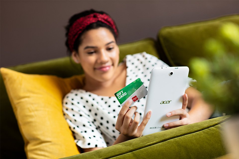 A woman uses a gift card whilst shopping online.